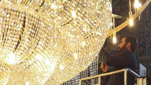 غبار روبی بزرگترین لوستر حرم حضرت معصومه(س)